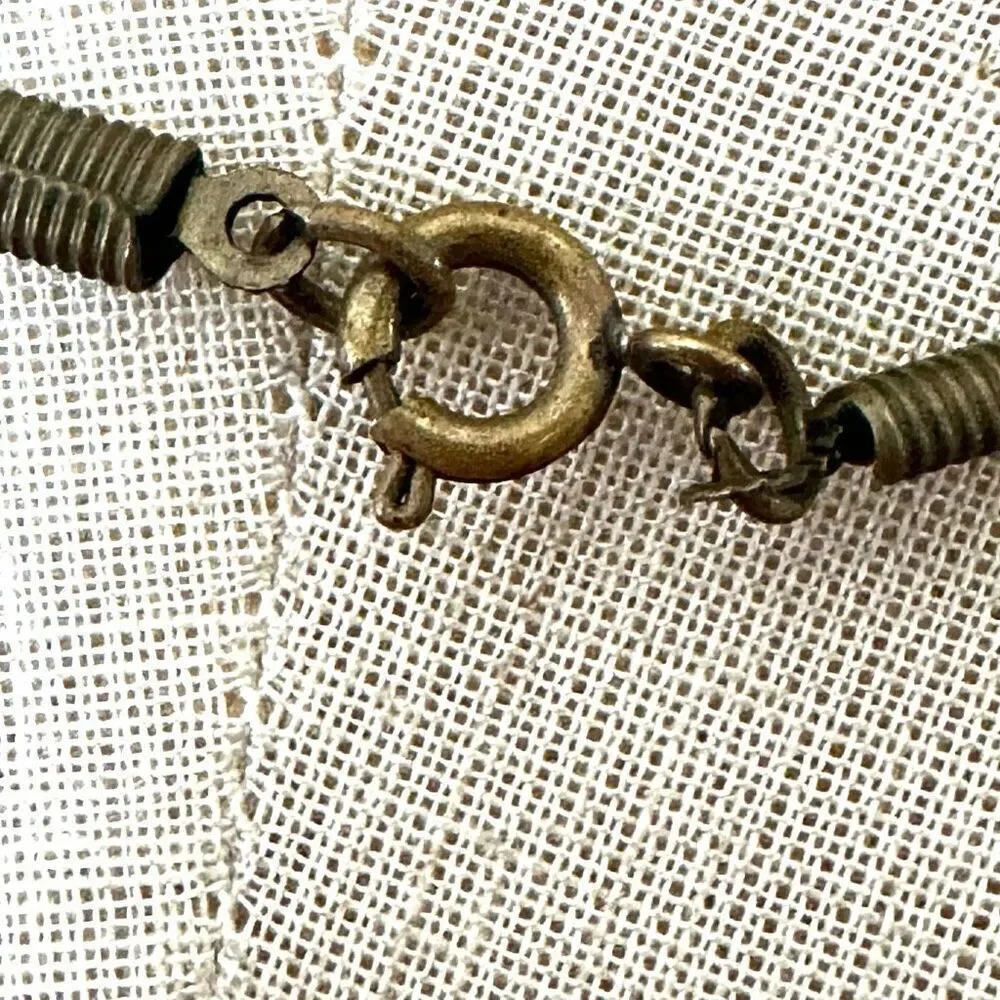 Green and gold tone pendant necklace on black cord
